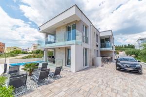 a house with a car parked in front of it at Apartments M&L in Vodice