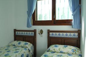 - une chambre avec 2 lits et une fenêtre dans l'établissement Estrella del Mar, à El Port de la Selva