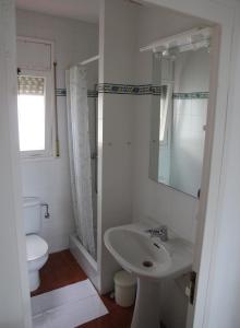 W łazience znajduje się umywalka, toaleta i lustro. w obiekcie Estrella del Mar w mieście Port de la Selva