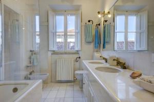 bagno con 3 lavandini, vasca e servizi igienici di Elegante Attico panoramico a 2 passi dal mare a Forte dei Marmi Altre 18 foto