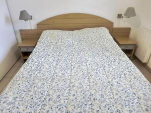 een bed met een blauwe en witte deken erop bij Apartment l'Allée des Dunes-9 by Interhome in Ondres