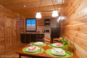 a kitchen and dining room with a table in a cabin at Domki letniskowe IWET in Darłowo