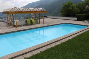 una piscina con cenador junto a una montaña en Residenza Trivento app. 9, en Rovio