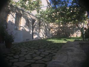 a building with a stone walkway in front of a yard at My Cave La Maison Du Reve in Uchisar