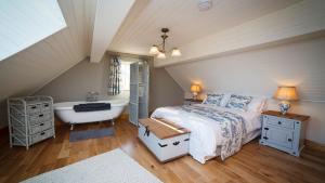 a bedroom with a bed and a bath tub at BaySide Cottage in Canower