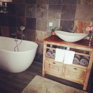 y baño con bañera, lavabo y toallas. en Karma oasis, en Saint-Joseph