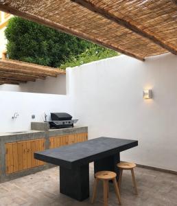 a black table and two stools in a patio at Ria Sunset House Alvor in Alvor
