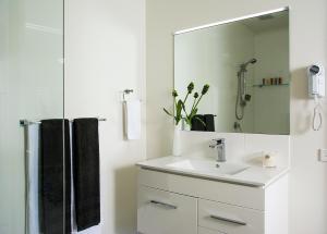 a white bathroom with a sink and a mirror at 1770 Lagoons Central Apartment Resort Official in Agnes Water