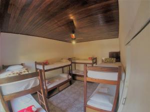 a room with four bunk beds and a wooden ceiling at Vibe Hostel Paraty in Paraty