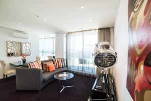 a living room filled with furniture and a large window at The Sebel Melbourne Docklands Hotel in Melbourne