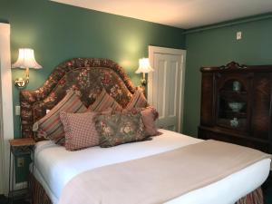 um quarto com uma cama grande e uma grande cabeceira. em Cleveland House Inn em Newport