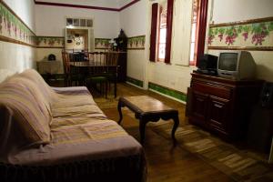 a living room with a couch and a tv at D. TERESINHA in Vila de Frades