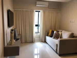 una sala de estar con un sofá y un televisor en Ondina Apart Hotel - Apto. 537, en Salvador