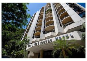 un edificio de apartamentos blanco y alto con un letrero. en Real Residence Hotel, en Río de Janeiro