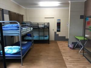 a room with three bunk beds in a prison at Mission Beach Retreat in Mission Beach