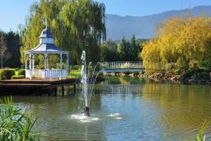 a fountain in the middle of a pond with a gazebo at Lakeside Cottage Luxury B&B in Mount Dandenong