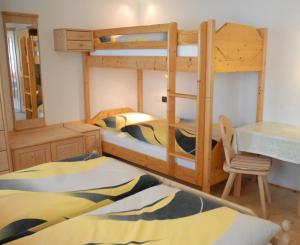 a bedroom with two bunk beds and a desk at Biohof Hamann in Sarntal