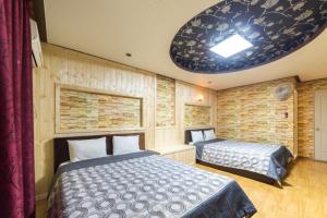 a bedroom with two beds and a ceiling at Venus Motel in Boryeong