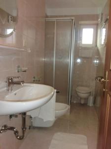 y baño con lavabo, aseo y ducha. en Residence Alpenrose, en Sesto