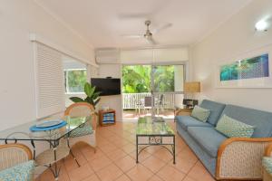a living room with a couch and a table at Coral Apartments Port Douglas in Port Douglas