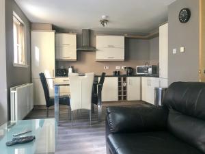 un soggiorno e una cucina con divano e tavolo di Glasgow Executive Apartments a Glasgow