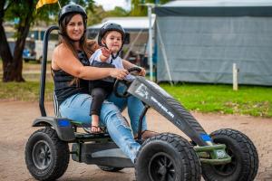 a woman and a child riding a toy vehicle at Discovery Parks - Bunbury in Bunbury