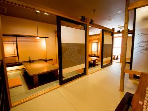 Habitación con mesa y algunas ventanas de cristal. en Naruto Grand Hotel Kaigetsu, en Naruto
