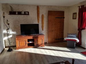 a living room with a television on a wooden entertainment center at Kleine Auszeit in Stolpe auf Usedom