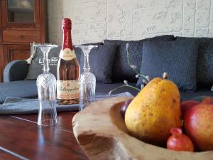 Kleine Auszeit في Stolpe auf Usedom: طاولة مع زجاجة من النبيذ وصحن من الفاكهة