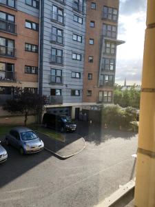 un'auto parcheggiata in un parcheggio accanto a un edificio di Glasgow Executive Apartments a Glasgow