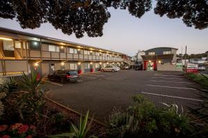 a parking lot with cars parked in front of a building at Landmark Manor in New Plymouth