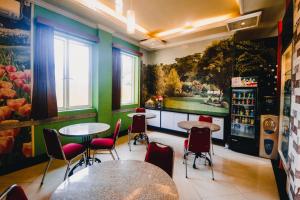 a restaurant with tables and chairs in a room at RedDoorz Plus @ Grand City Inn in Makassar