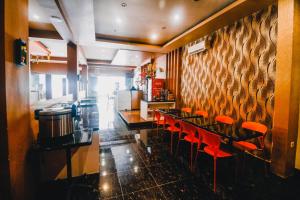 Reddoorz Plus near Makassar Town Square في ماكاسار: مطعم بطاولة طويلة وكراسي حمراء