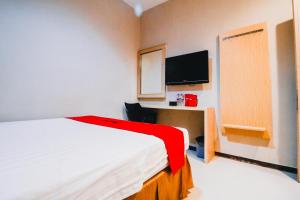 Un pat sau paturi într-o cameră la RedDoorz Plus near Sultan Hasanuddin Airport