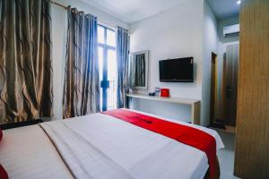 Tempat tidur dalam kamar di RedDoorz Plus near Sultan Hasanuddin Airport