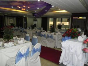 een feestzaal met witte tafels en blauwe stoelen bij Lourdes Suites in Manilla
