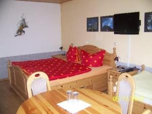 a bedroom with a bed and a table and chairs at Pension Strohbach in Sebnitz