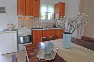 a kitchen with a table with a vase on it at Echinades Resort in Vasiliki