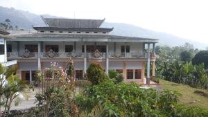 a large white house with a balcony on a hill at Hotel Nadia Bromo in Bromo