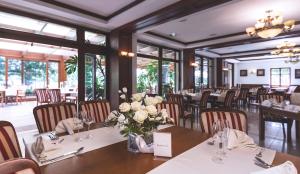 ein Esszimmer mit Tischen und Stühlen, die mit Blumen geschmückt sind in der Unterkunft Hotel Barlinek in Barlinek