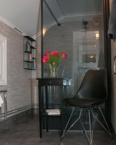 a black chair and a table with a vase of flowers at Ekeby i Bro in Bro +7 photos