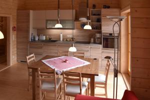 kuchnia i jadalnia z drewnianym stołem i krzesłami w obiekcie Erzgebirgsholzhaus am Lugstein w mieście Altenberg
