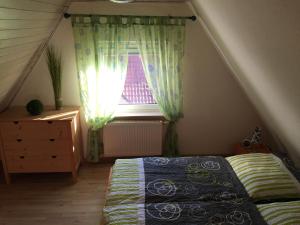 a attic bedroom with a bed and a window at Ferienhaus Heinrich in Egloffstein