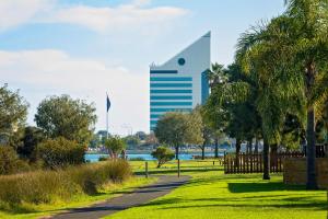 a park with a tall building in the background at Discovery Parks - Bunbury Foreshore in Bunbury