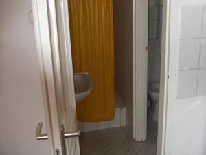 a bathroom with a sink and a yellow shower curtain at Németh Apartmanok in Zalakaros