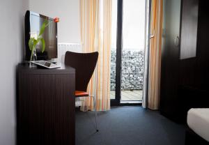 Zimmer mit einem Schreibtisch mit einem Stuhl und einem Fenster in der Unterkunft GS Hotel Mindelheim in Mindelheim