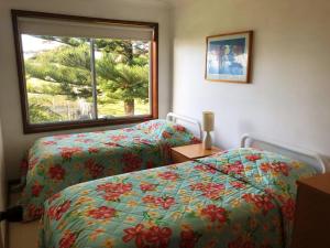 
a hotel room with two beds and two windows at 3 Bay Lane in Kianga

