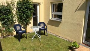 2 sillas y una mesa de cristal en un patio en Ferienwohnung Moin, en Kiel