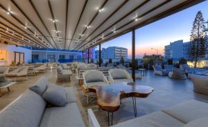 a rooftop lounge with white furniture and a view of the city at The Blue Ivy Hotel & Suites in Protaras