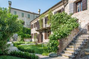 an old building with a staircase in a garden at Casa Zorzi in Arqua Petrarca